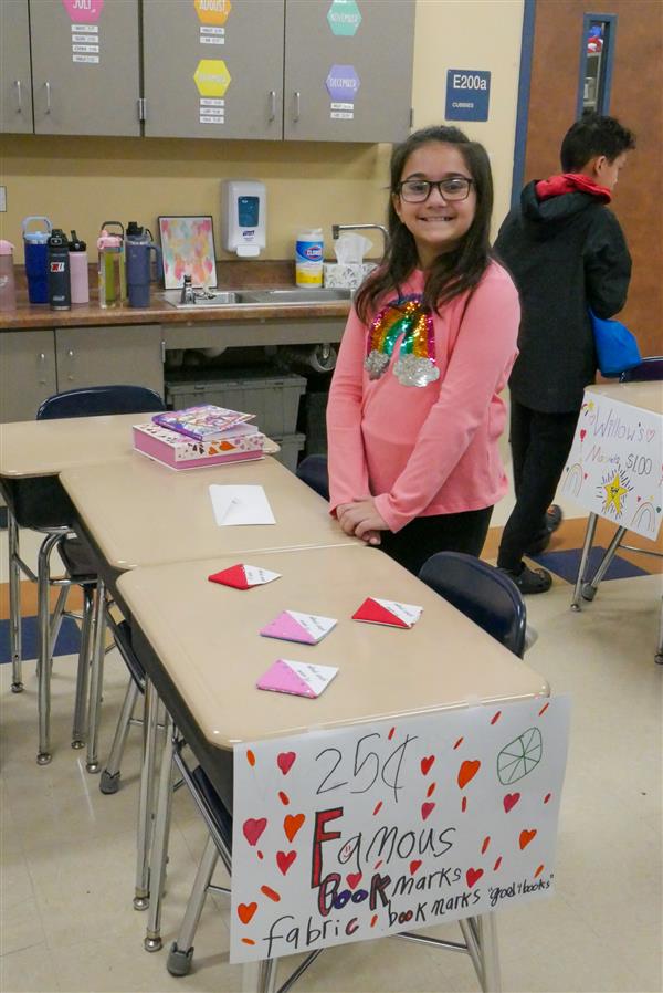 girl at desk with pink and red paper
